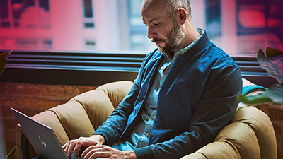 Developer sat on armchair with AMD laptop