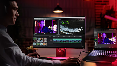 Content creator working with creative software between a PC and a laptop