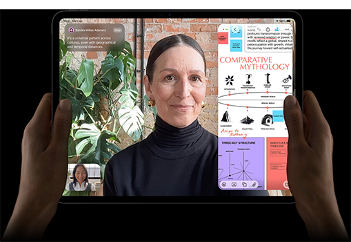 iPad Pro, front exterior, space black colour, left and right hands holding in landscape orientation, display showing a FaceTime conversation being live translated to highlight connectivity