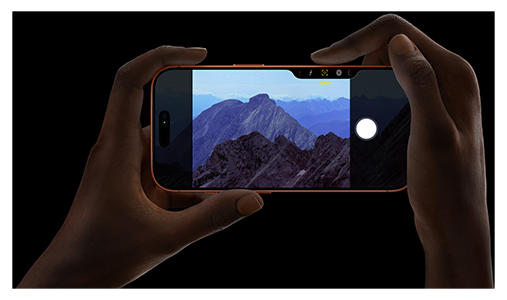Hands holding iPhone Pro in landscape position, taking a picture of a mountain