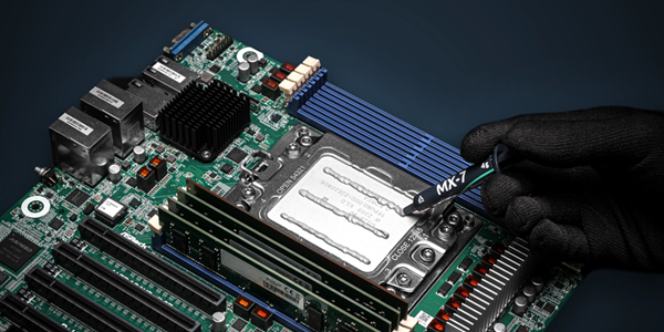 Motherboard with thermal paste being applied by hand to CPU.