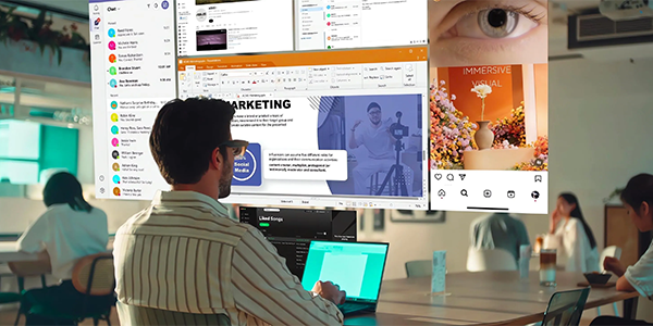 Man on laptop working in office wearing ASUS AirVision M1 glasses with illustration of multi-screen layout infront of his face.