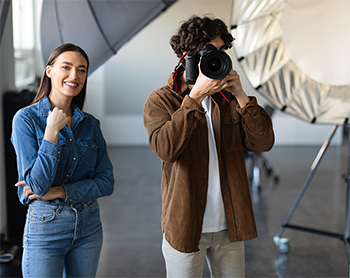 studio set with excited lady and man filming with camera