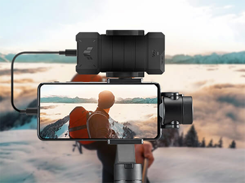 SSD enclosure in tripod connected to phone against camera