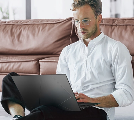 Man sat down, typing on a Zenbook