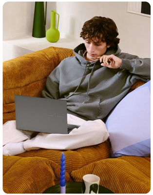 Student sat on couch while focusing on laptop