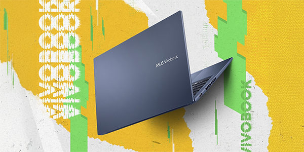 Rear angle of laptop with yellow, green and white cardboard textured background.