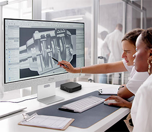 People looking at a monitor with mini pc beside it