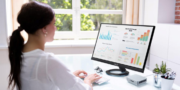 Monitor, keyboard and mouse on desk beside the ASUS NUC