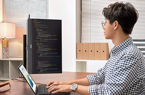 Student coding in office with monitor flipped vertically