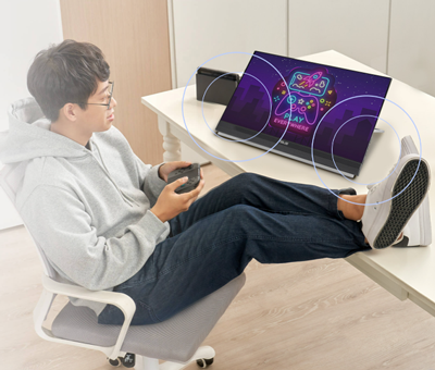 Man lying in chair looking at monitor with speakers highlighted