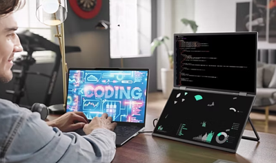 Man multitasking with PD3 dual screens connected to laptop.