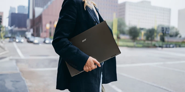 Woman carrying PD3 monitor across a road, highlighting portability.