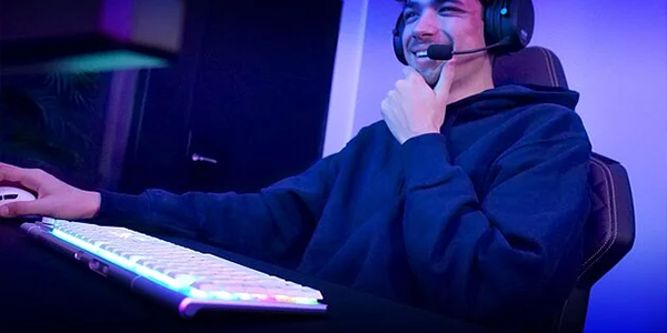 PC gamer sat at a desk beside the keyboard with a satisfied expression