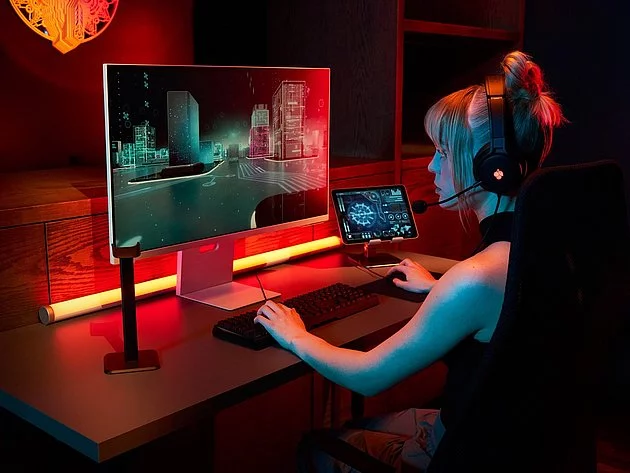 Woman wearing headset plays video game on computer