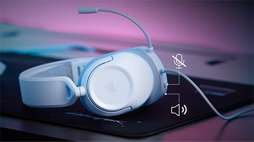White headphones flat on desk with audio buttons shown