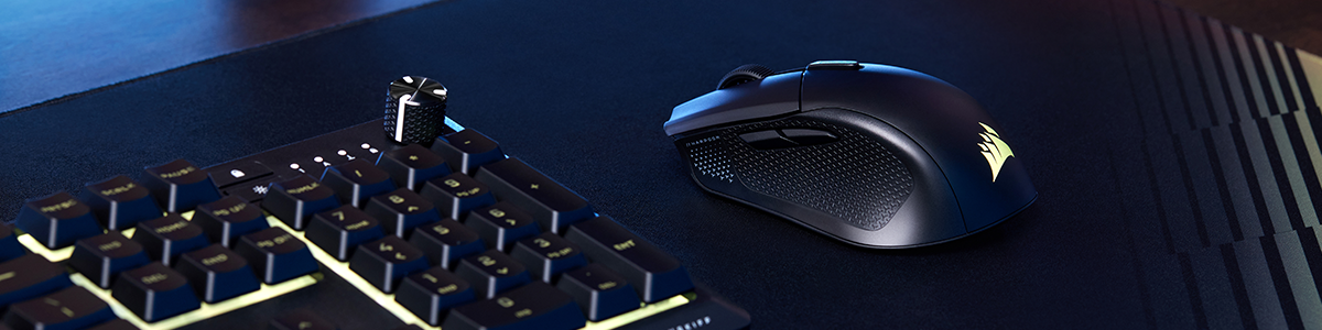 Left angle of HARPOON v2 gaming mouse next to keyboard on top of a large dark mouse mat.