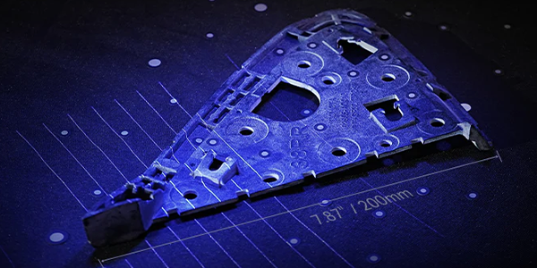 Engineered metal part with grid line illustrations overlaying it.