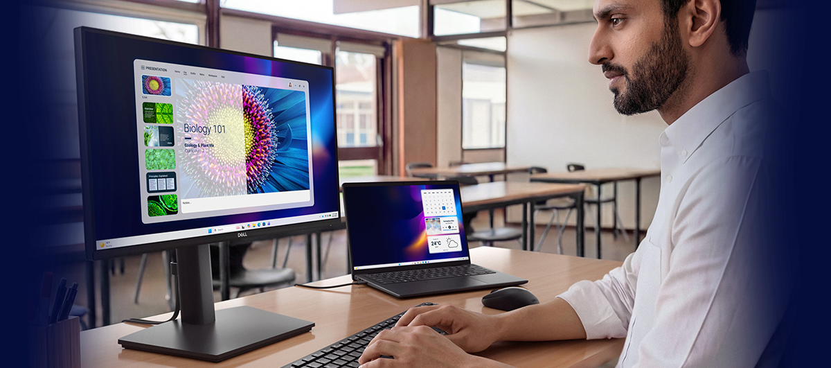 Banner style image of a man at a desk using the monitor