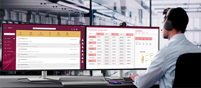 Lifestyle photo of Dual Pro 32 Plus monitors in a office with business man working on them