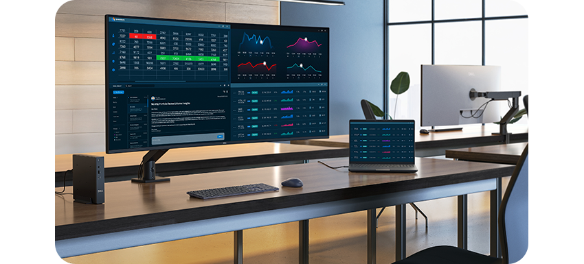 Lifestyle photo of the monitor on a desk next to a laptop