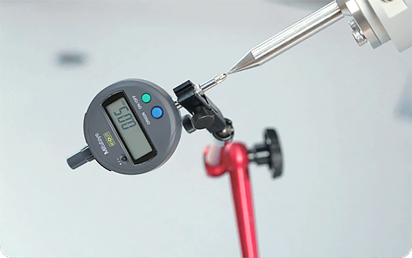 Precision measurement being taken of the X-Trainer's slave hands, achieving ±0.05mm accuracy