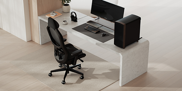 Refine 2 chair next to full desk setup with PC, monitor and peripherals.