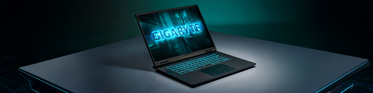 GAMING A16 laptop on a grey table with light blue lit edges with black and dark cyan gradient background.