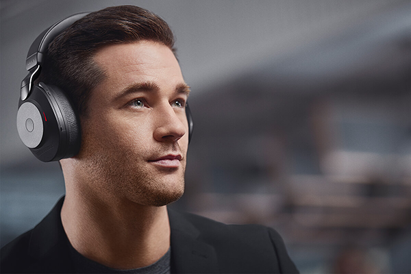 Key visual of man wearing Jabra Evolve2 85 headset with busylight on.