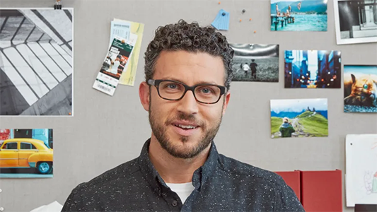 Balanced view of smiling man, focusing on his face and a little of his surroundings.