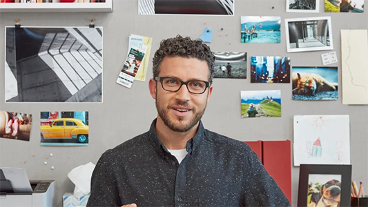 Full view of smiling man, showing himself and a 90-degree area of his surroundings.
