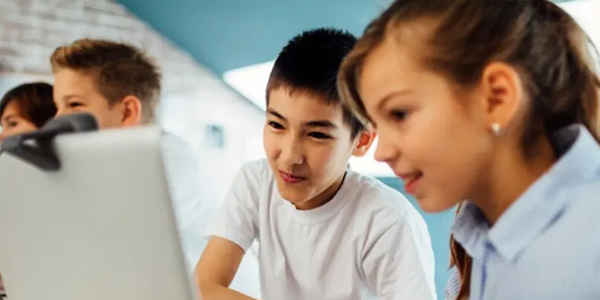 Happy students using C720 webcam on monitor.