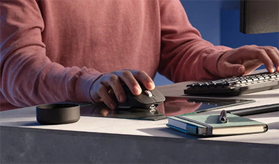 Image of a man using the mouse on a glass mouse pad.