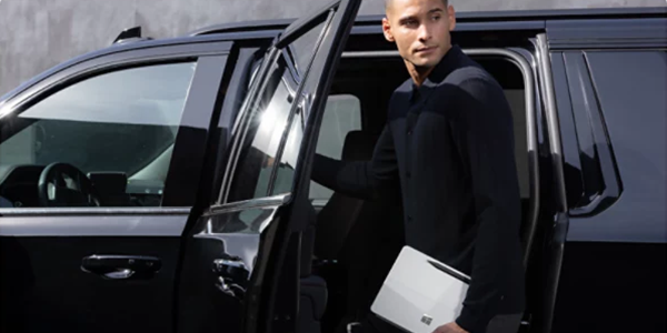 Agent entering SUV with Surface Pro in hand to illustrate protection