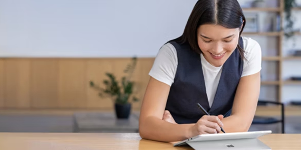 Woman in office, using her slim pen on the Surface Pro