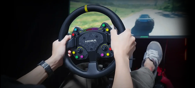 Hands holding racing wheel with racing game on screen infront.