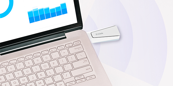 Close up view of top corner of open laptop, with D-Link AX18U WiFi6 adapter plugged into the side.