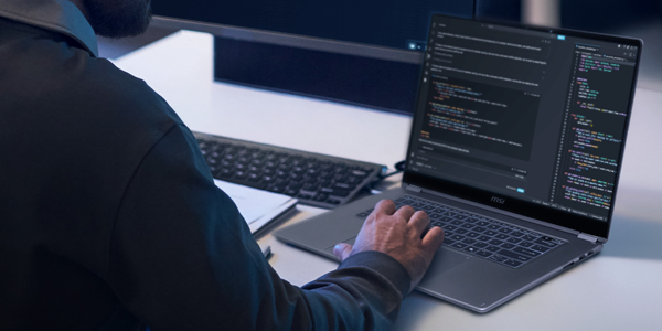 Man in suit typing on laptop keyboard.