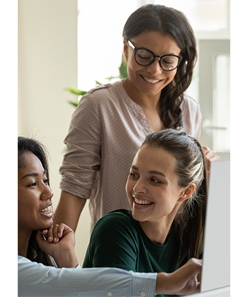 Lifestyle image of three women in front of a computer during a class