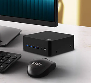 MSI Cubi on desk beside computer peripherals.
