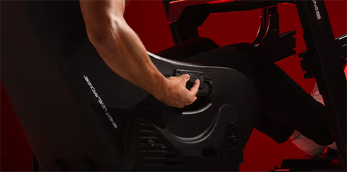 Lifestyle image of a man sitting in the chair using the controller to adjust it