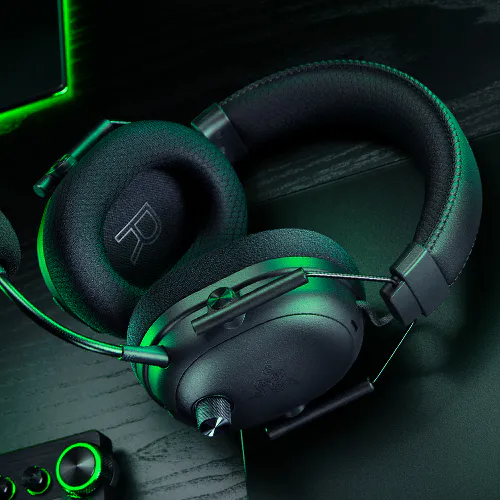 Razer Blackshark V3 Pro lying flat on a desk with other Razer peripherals