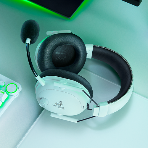 Razer Blackshark V3 Pro lying flat on a desk with other Razer peripherals