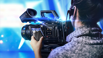 Videographer adjusting camera with SSD in hand