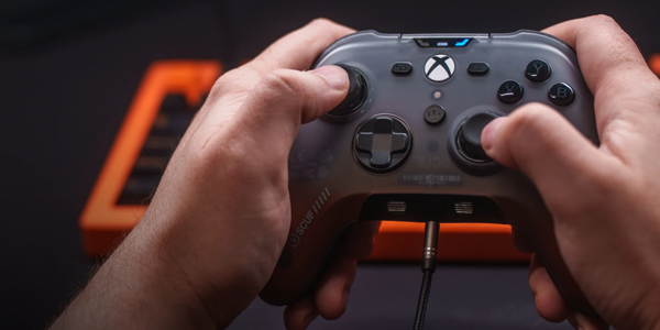 Two hands gripping the controller with thumbs moving the thumbsticks.