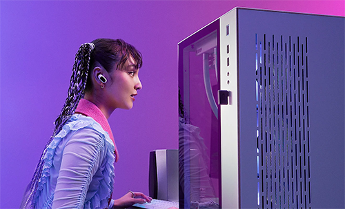 Image of a woman using the INZONE Buds whilst playing on a PC