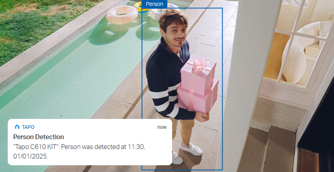 Man holding gifts outside house with person detection notification overlaid.