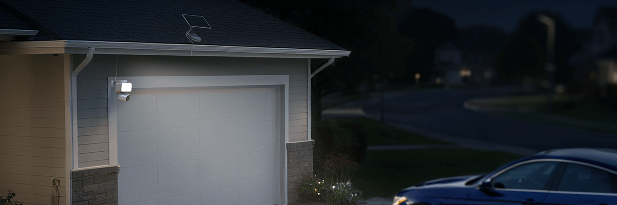 Home garage with blue car parked outside on drive.