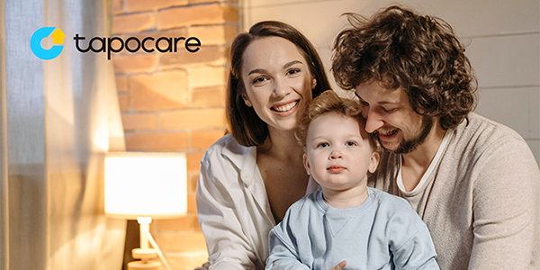 Happy family sat on a bed.