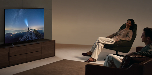 Couple sat on couches watching TV